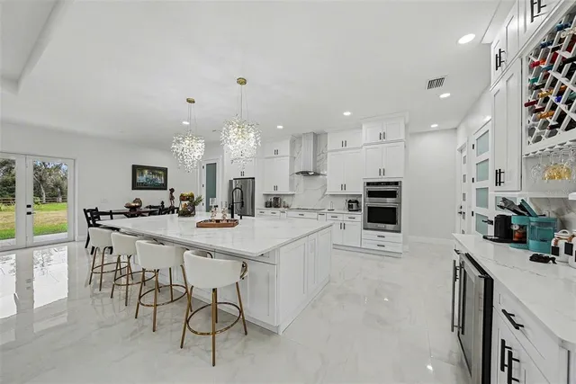 a kitchen with kitchen island granite countertop lots of white cabinets and stainless steel appliances