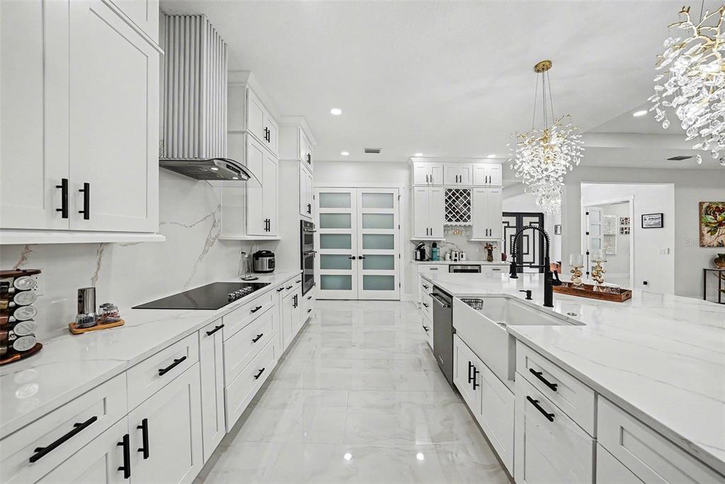 14060 Sydney Road Dover, FL 33527 - Photo 22 of 49 a large kitchen with granite countertop a sink dishwasher a stove and a dining table with wooden floor