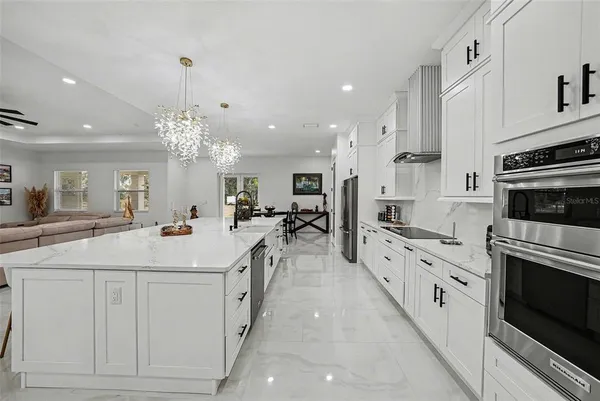 a large white kitchen with a stove top oven