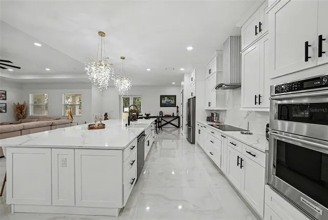 a large white kitchen with a stove top oven