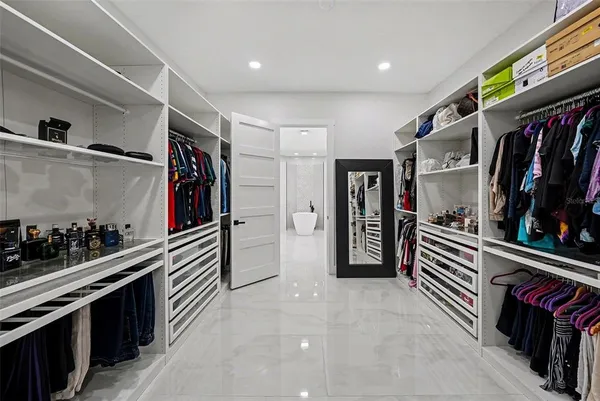 a hallway with a white cabinets and wooden floor