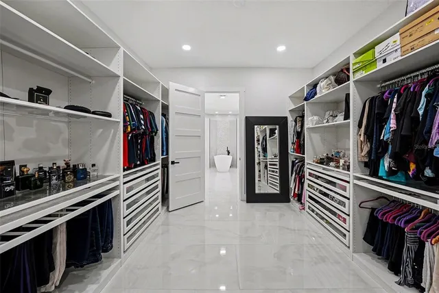a hallway with a white cabinets and wooden floor