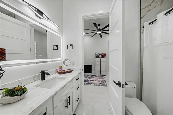 a bathroom with a sink a toilet and a mirror