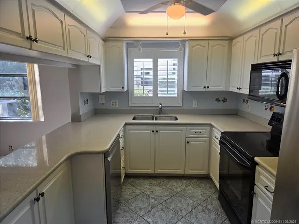 a kitchen with cabinets appliances a sink and a window