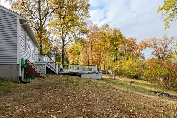 a view of a backyard with large trees and wooden fence