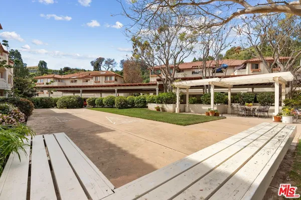 a view of a building with a yard and sitting area