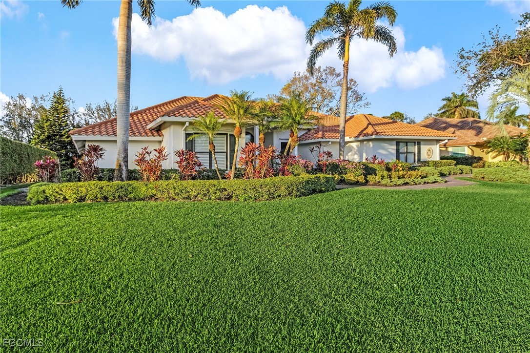 15661 Fiddlesticks Boulevard Fort Myers, FL 33912 - Photo 34 of 42 a view of a white house with a big yard and large trees