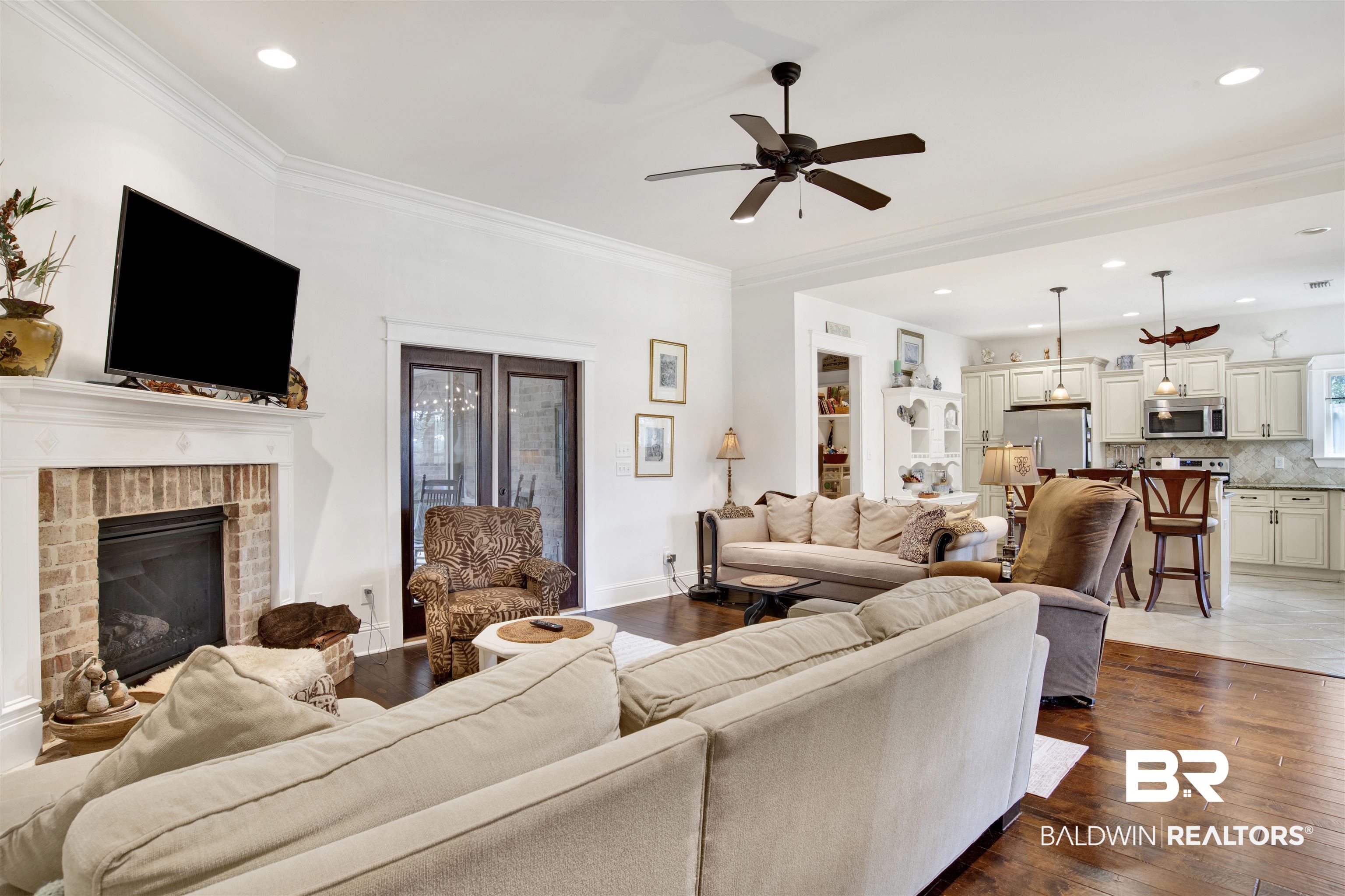 9240 Bay Point Drive Elberta, AL 36530 - Photo 8 of 22 Living room with wood-type flooring, a brick fireplace, crown molding, and ceiling fan