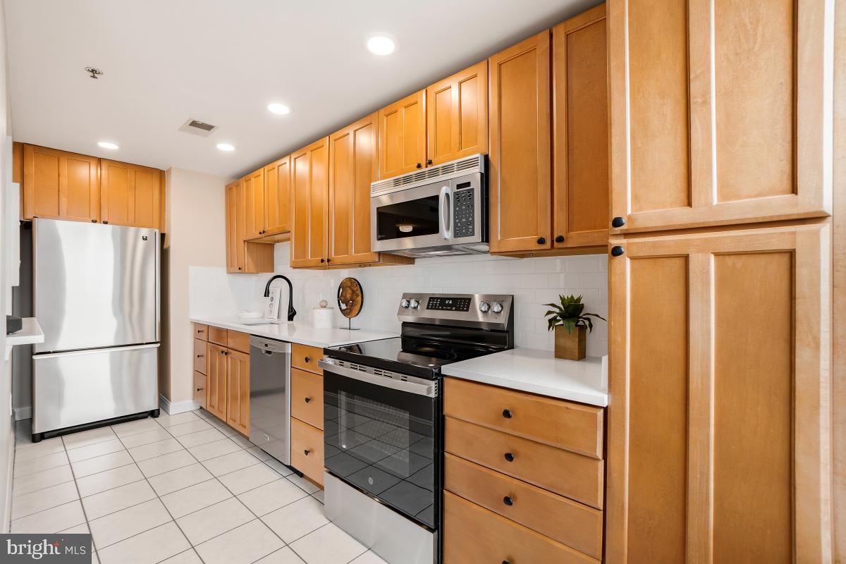 1621 T Street Northwest, Unit PH02 Washington, DC 20009 - Photo 13 of 30 a kitchen with granite countertop cabinets stainless steel appliances and a window
