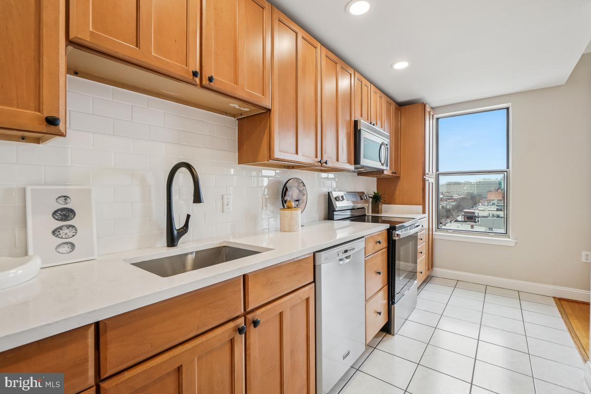 1621 T Street Northwest, Unit PH02 Washington, DC 20009 - Photo 14 of 30 a kitchen with kitchen island granite countertop a sink a stove cabinets and a window