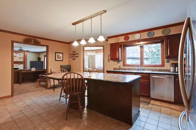 233 Perth Road Cary, IL 60013 - Photo 7 of 24 a kitchen with a sink a counter space dining space and a large window