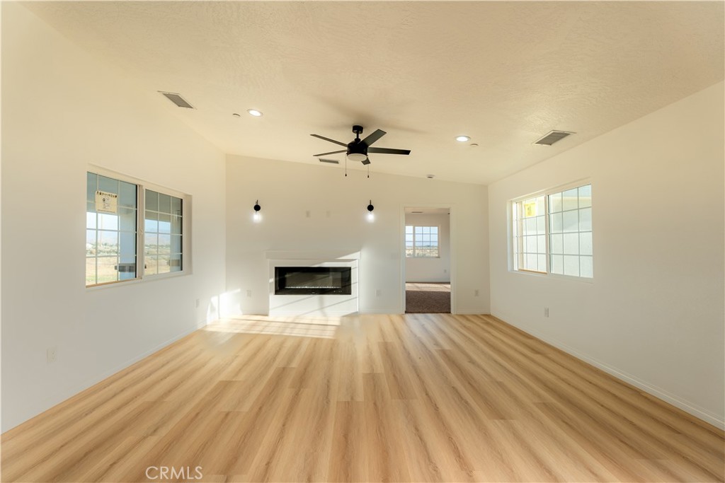 16925 Nanticoke Road Apple Valley, CA 92307 - Photo 47 of 87 a view of a livingroom with wooden floor a ceiling fan and windows