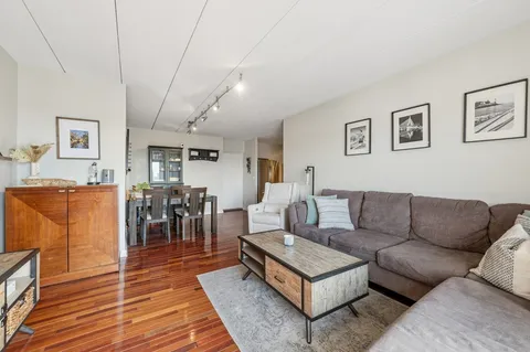 a living room with furniture a wooden floor and next to a window