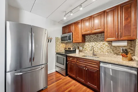 a kitchen with granite countertop stainless steel appliances and wooden cabinets