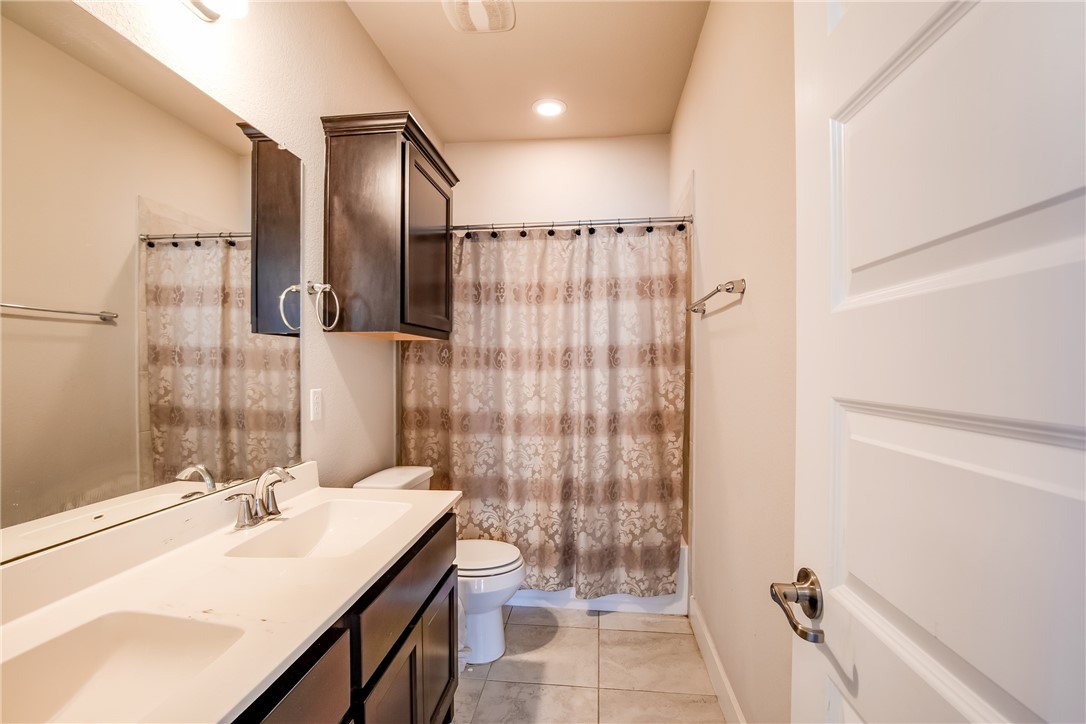 9707 McKnight Loop Austin, TX 78717 - Photo 14 of 17 a bathroom with a double vanity sink toilet mirror and shower