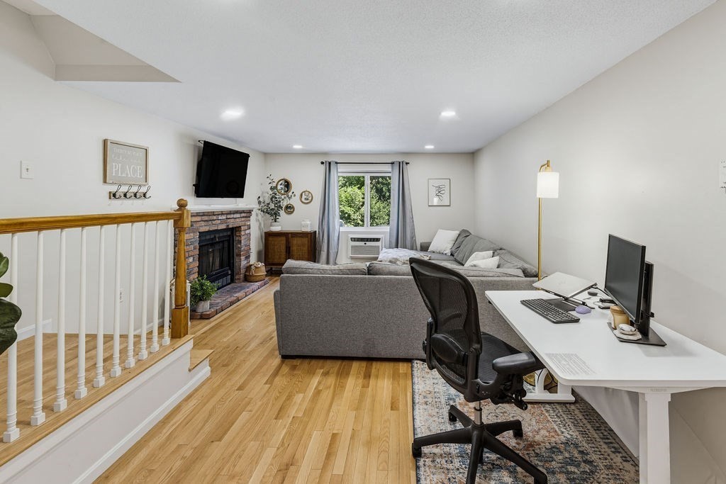 10 Erick Road, Unit 42 Mansfield, MA 02048 - Photo 10 of 33 a living room with furniture a flat screen tv and a fireplace