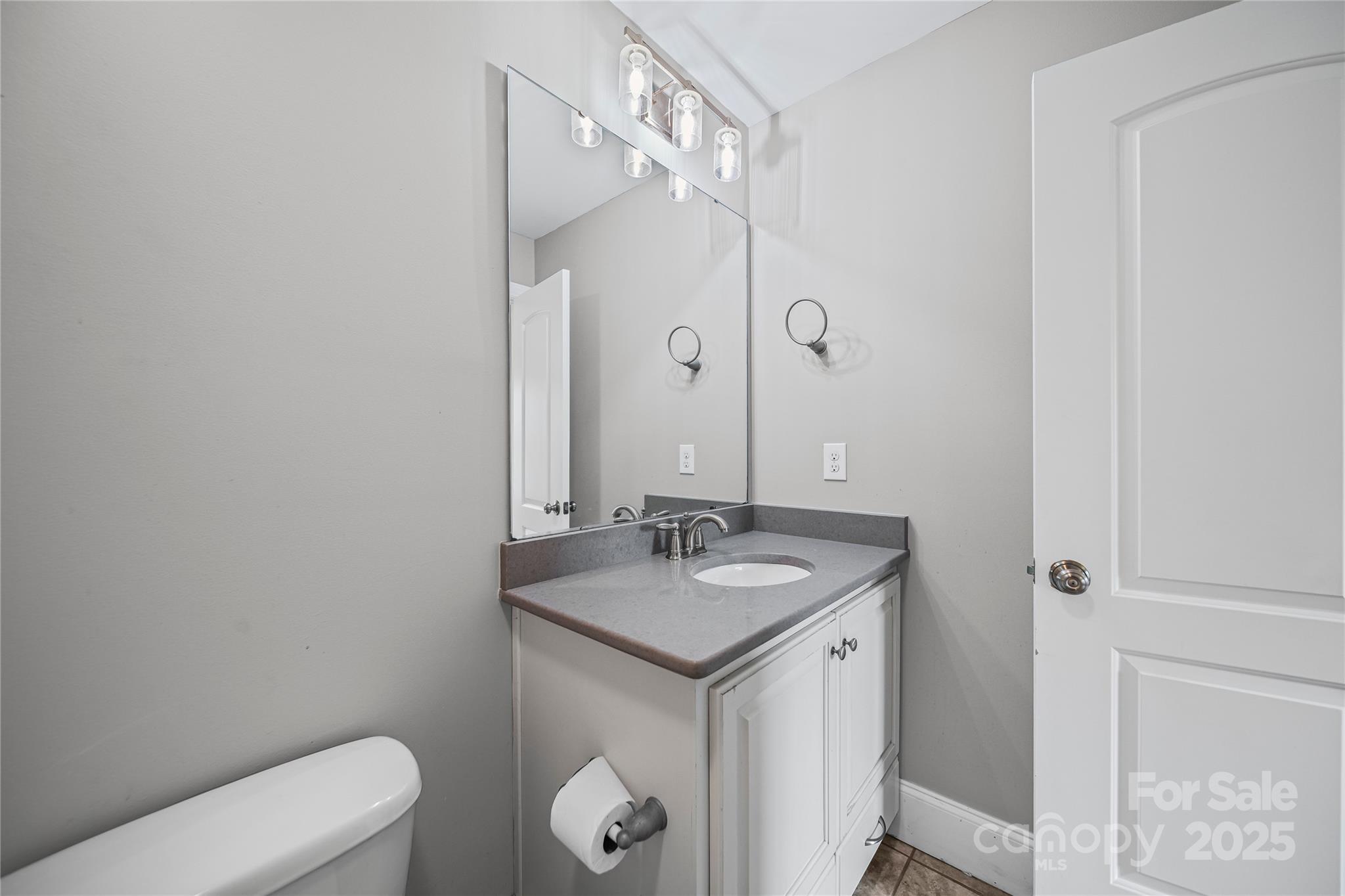1556 Diggs Road Wadesboro, NC 28170 - Photo 30 of 48 a bathroom with a granite countertop sink a toilet and a mirror