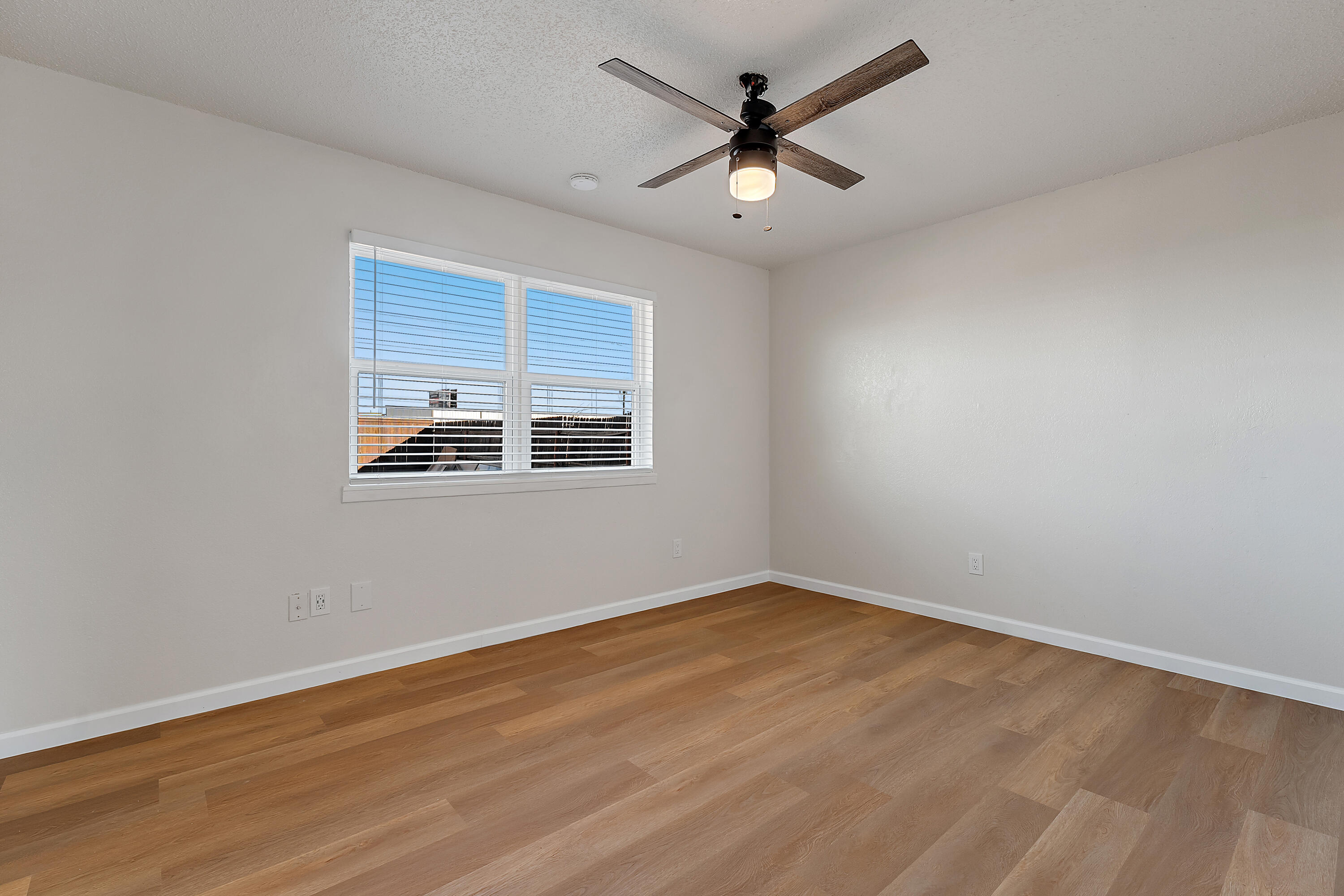 726 11th Street Wolfforth, TX 79382 - Photo 11 of 22 an empty room with wooden floor and windows