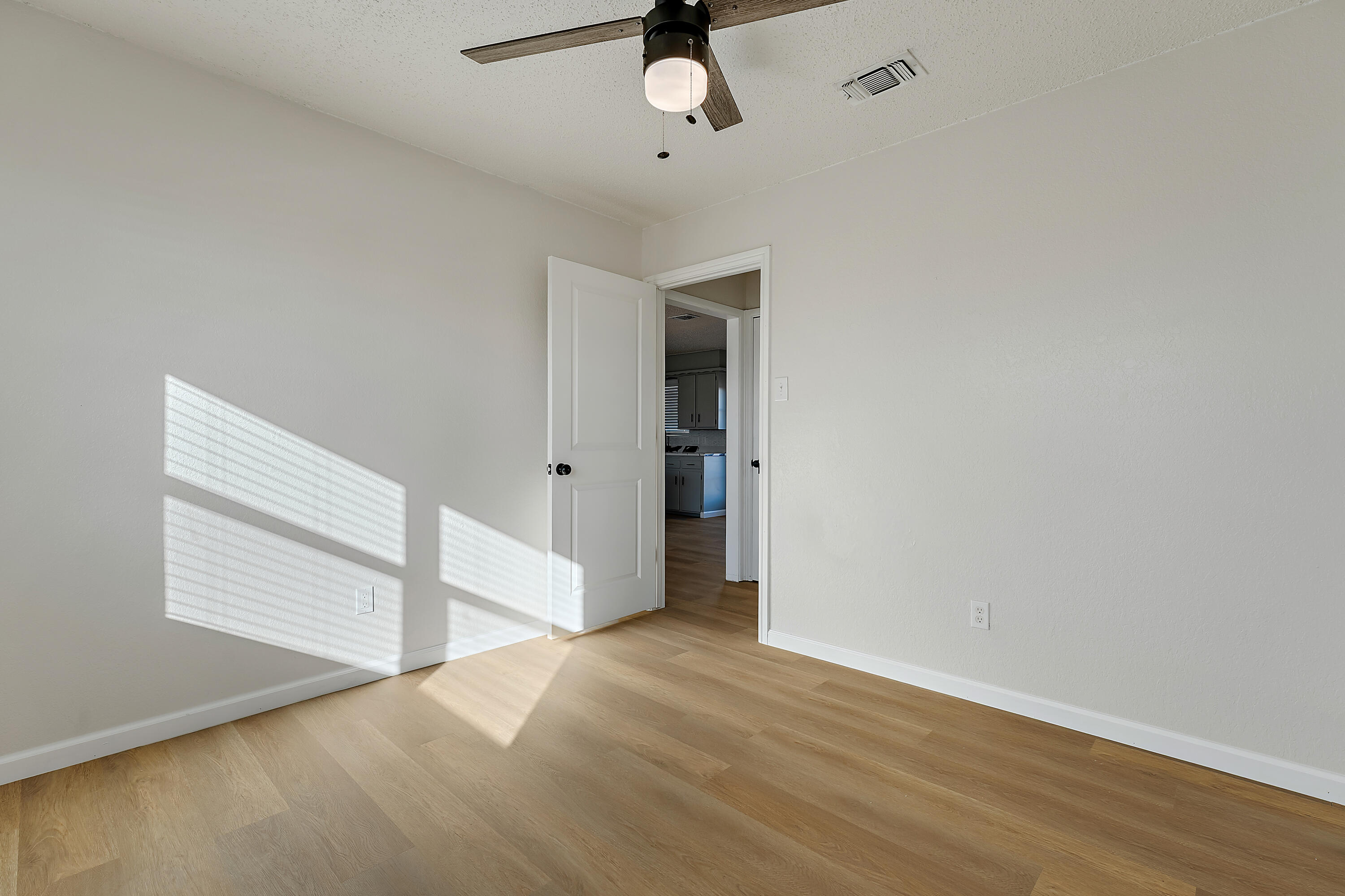 726 11th Street Wolfforth, TX 79382 - Photo 18 of 22 an empty room with wooden floor cabinet and windows