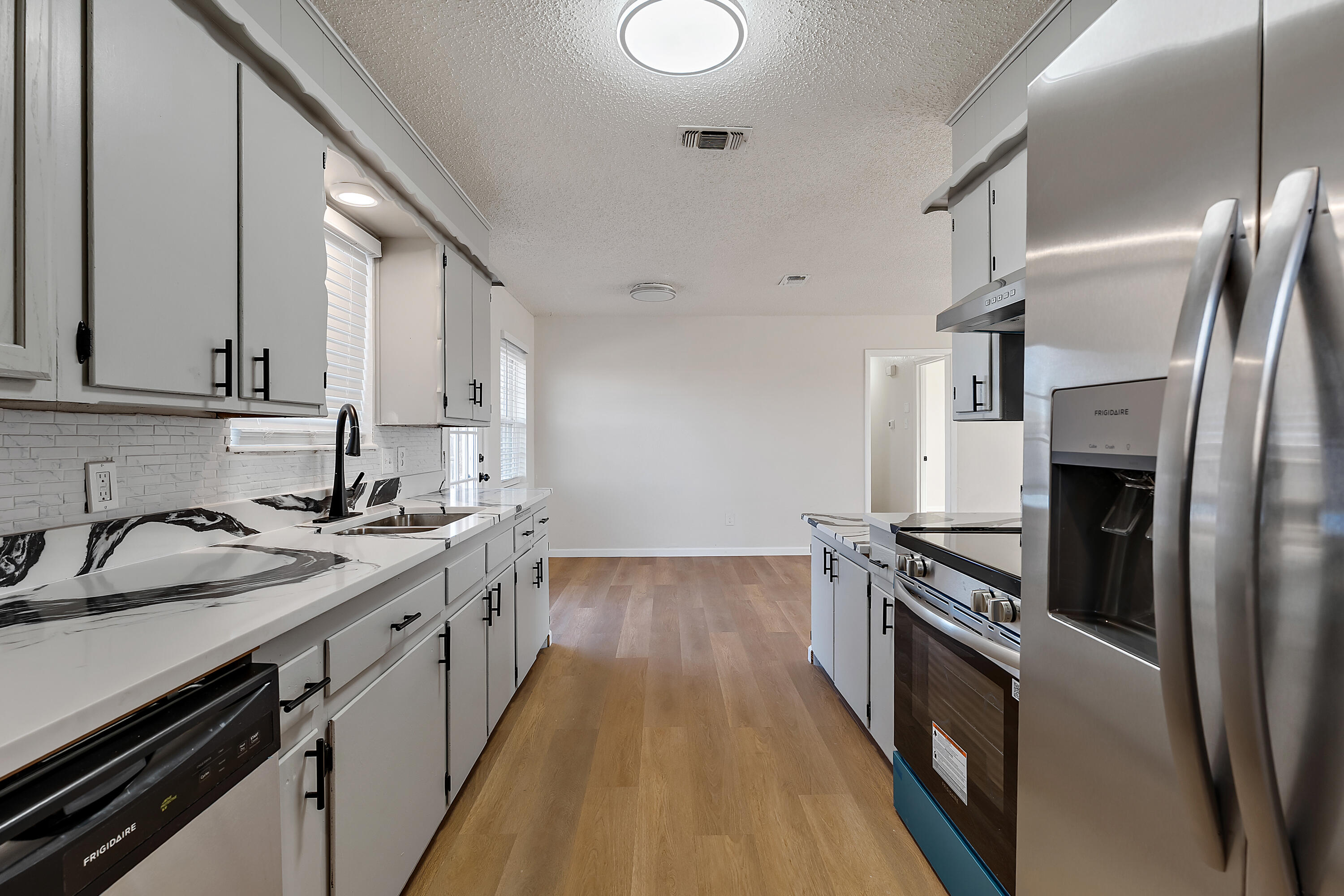 726 11th Street Wolfforth, TX 79382 - Photo 10 of 22 a kitchen with stainless steel appliances a sink stove and cabinets