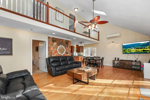 a dining hall with couches a dining table and chairs with wooden floor