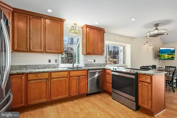 a kitchen with stainless steel appliances granite countertop a refrigerator and a sink