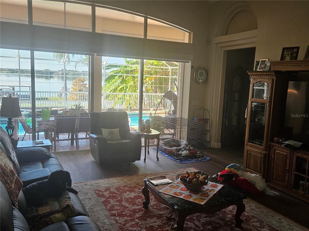 116 Raintree Court Auburndale, FL 33823 - Photo 10 of 45 a living room with furniture a flat screen tv and a floor to ceiling window