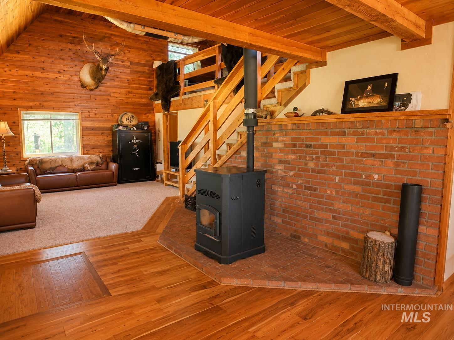 40 Atkin Lane Cascade, ID 83611 - Photo 4 of 46 Bedroom featuring extensive wood paneling on walls and ceiling, twin windows providing natural light, and a plush carpeted floor