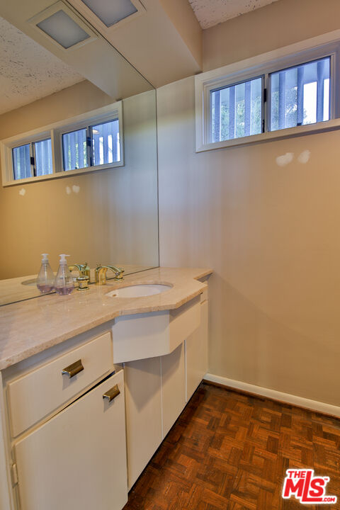 1749 Mandeville Lane Los Angeles, CA 90049 - Photo 15 of 38 a bathroom with a sink and a mirror