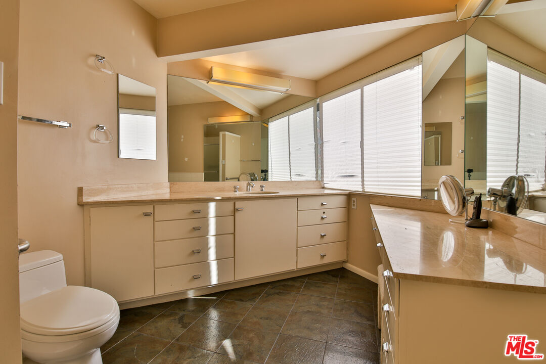 1749 Mandeville Lane Los Angeles, CA 90049 - Photo 19 of 38 a bathroom with a granite countertop sink mirror vanity and toilet