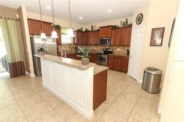 a kitchen with stainless steel appliances granite countertop a refrigerator and a stove