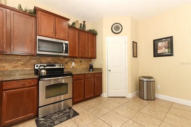 a kitchen with stainless steel appliances granite countertop a refrigerator stove top oven and sink