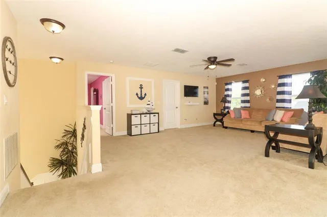 a view of a livingroom with furniture and a ceiling fan