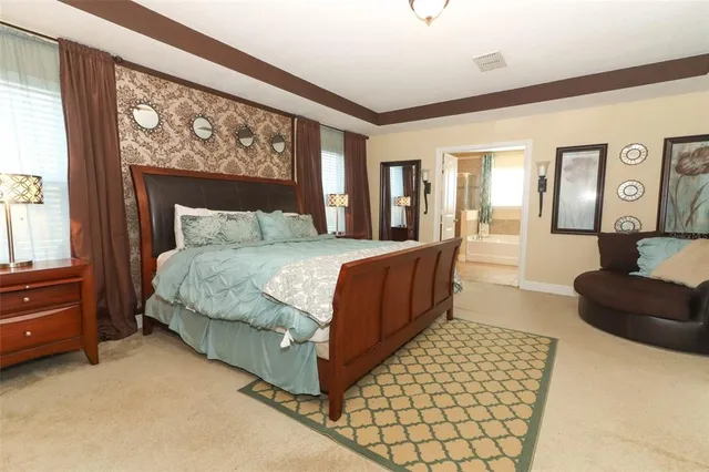 a bedroom with a bed lamp and a large window