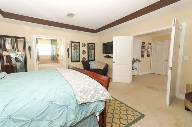 a spacious bedroom with a bed and a view of living room
