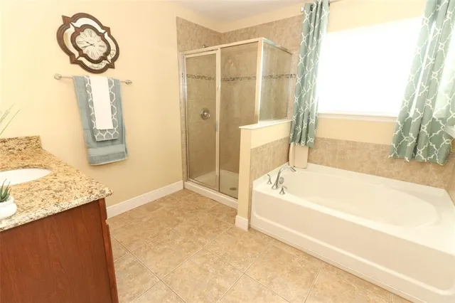a bathroom with a granite countertop sink and a bathtub