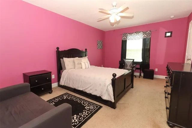 a spacious bedroom with a bed and a chandelier