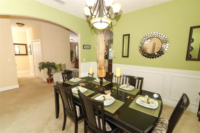 a view of a dining room with furniture and a chandelier