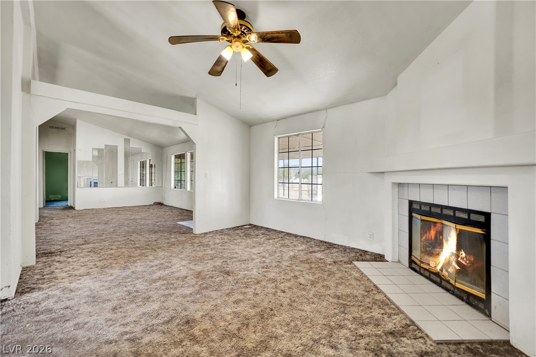4361 Maple Road Pahrump, NV 89048 - Photo 18 of 46 A generous living area presents a cozy fireplace with tiled hearth and a ceiling fan for climate control.