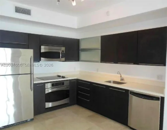 a kitchen with a sink and a stove top oven