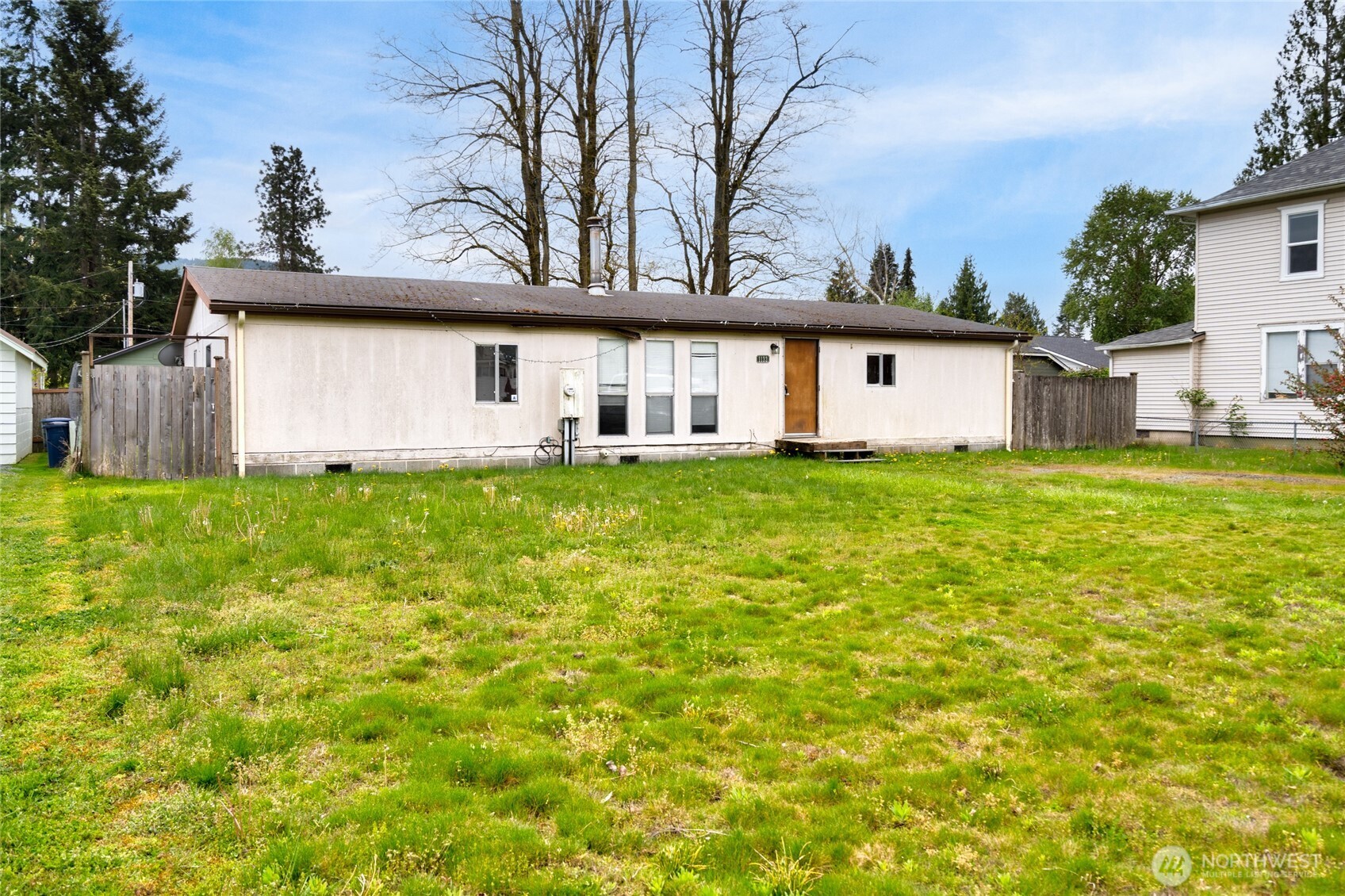 a view of a house with a yard and a large tree