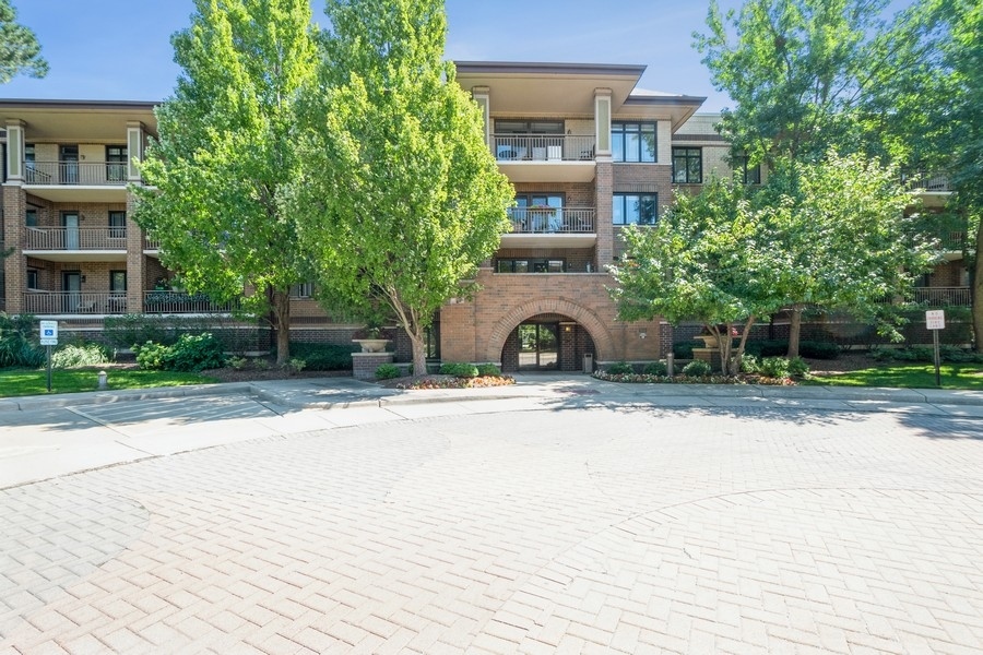 9220 East Prairie Road, Unit 303 Evanston, IL 60203 - Photo 1 of 13 a front view of a house with a yard and garage