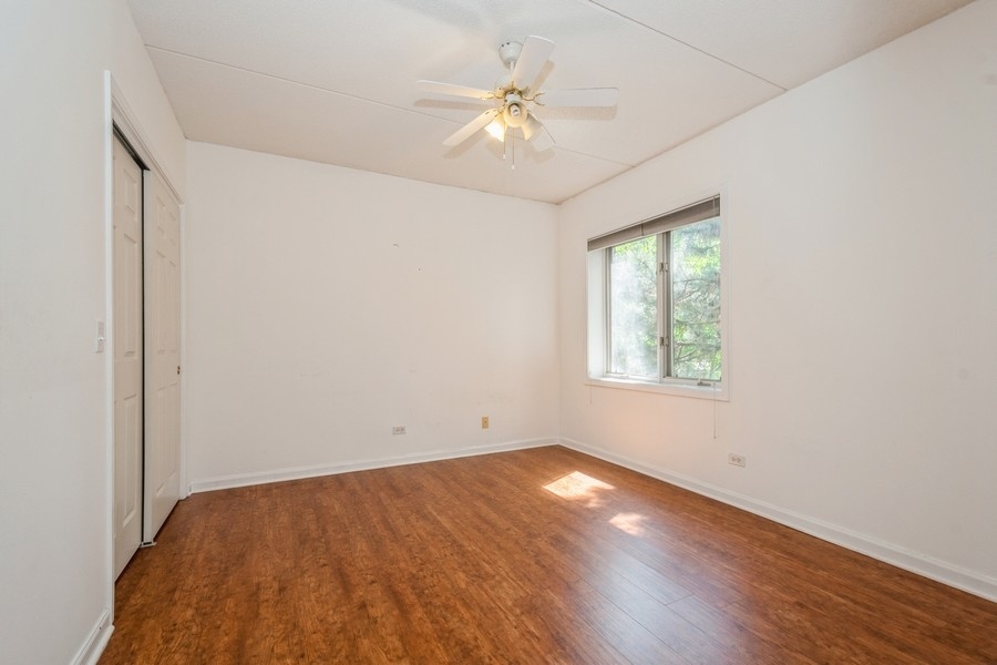 9220 East Prairie Road, Unit 303 Evanston, IL 60203 - Photo 8 of 13 an empty room with a window and a ceiling fan