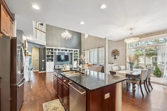 a kitchen with granite countertop a stove and a dining table with wooden floor