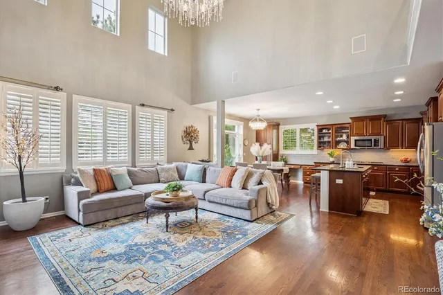 a living room with furniture kitchen view and large windows