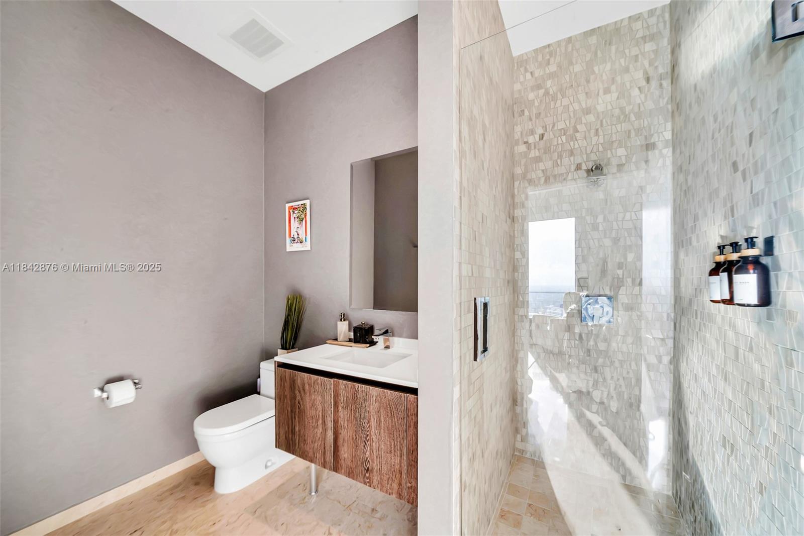 88 Southwest 7th Street, Unit 4004 Miami, FL 33130 - Photo 17 of 24 a bathroom with a sink a toilet and a mirror