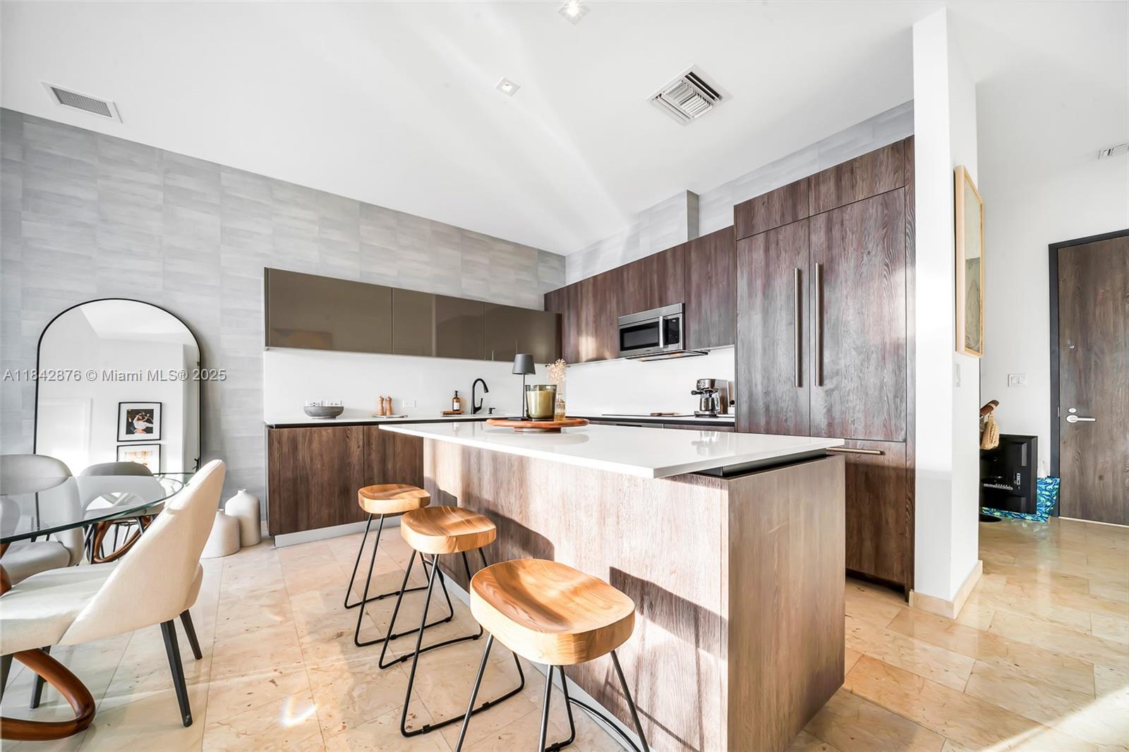 88 Southwest 7th Street, Unit 4004 Miami, FL 33130 - Photo 6 of 24 a kitchen with stainless steel appliances kitchen island a stove a sink a refrigerator and chairs with wooden floor