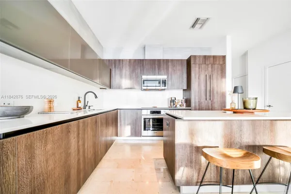 a view of a kitchen with fridge and workspace