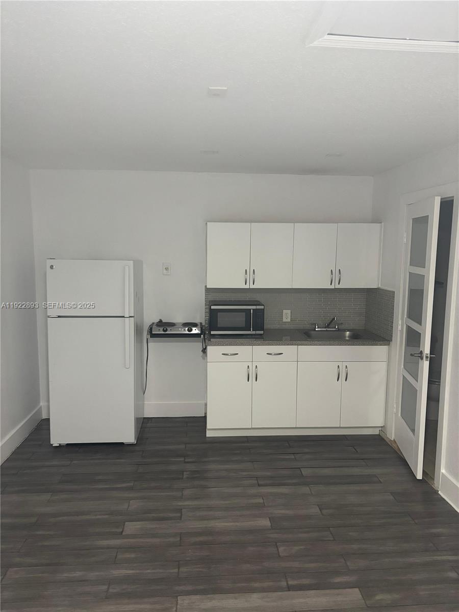 15535 Southwest 10th Street, Unit EFFICIENCY Miami, FL 33194 - Photo 3 of 10 a kitchen with granite countertop white cabinets and refrigerator