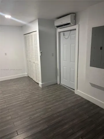 an empty room with wooden floor and closet